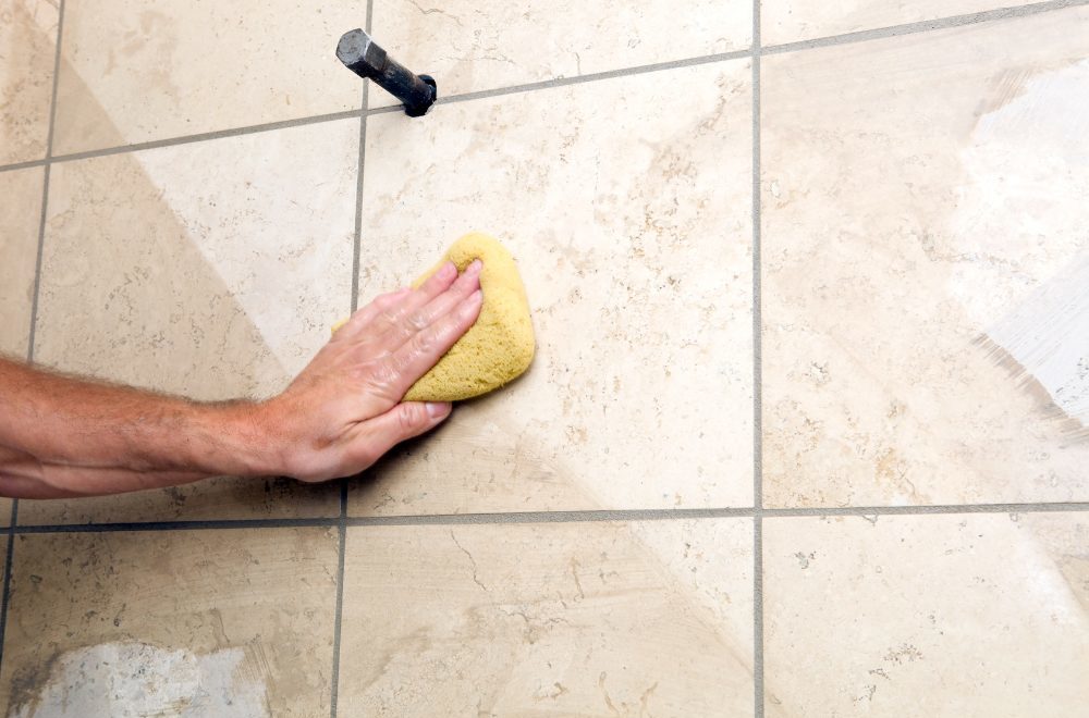 closeup of someone performing limestone cleaning on bathroom tiles